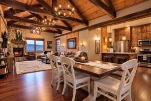A spacious living area with a fireplace, dining table, and kitchen area with wooden cabinets and appliances.
