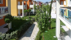 A residential building with a central courtyard, featuring a paved walkway and greenery. - Lovely apartment for 5 people with WIFI, A/C, pool, TV and terrace (Jesolo)