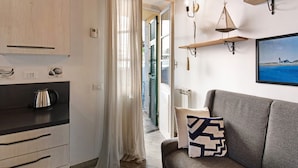 Una cocina moderna con un hervidor, un armario de madera y vistas al exterior.