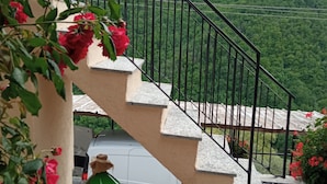 A staircase with a metal railing leading to a mountain view.