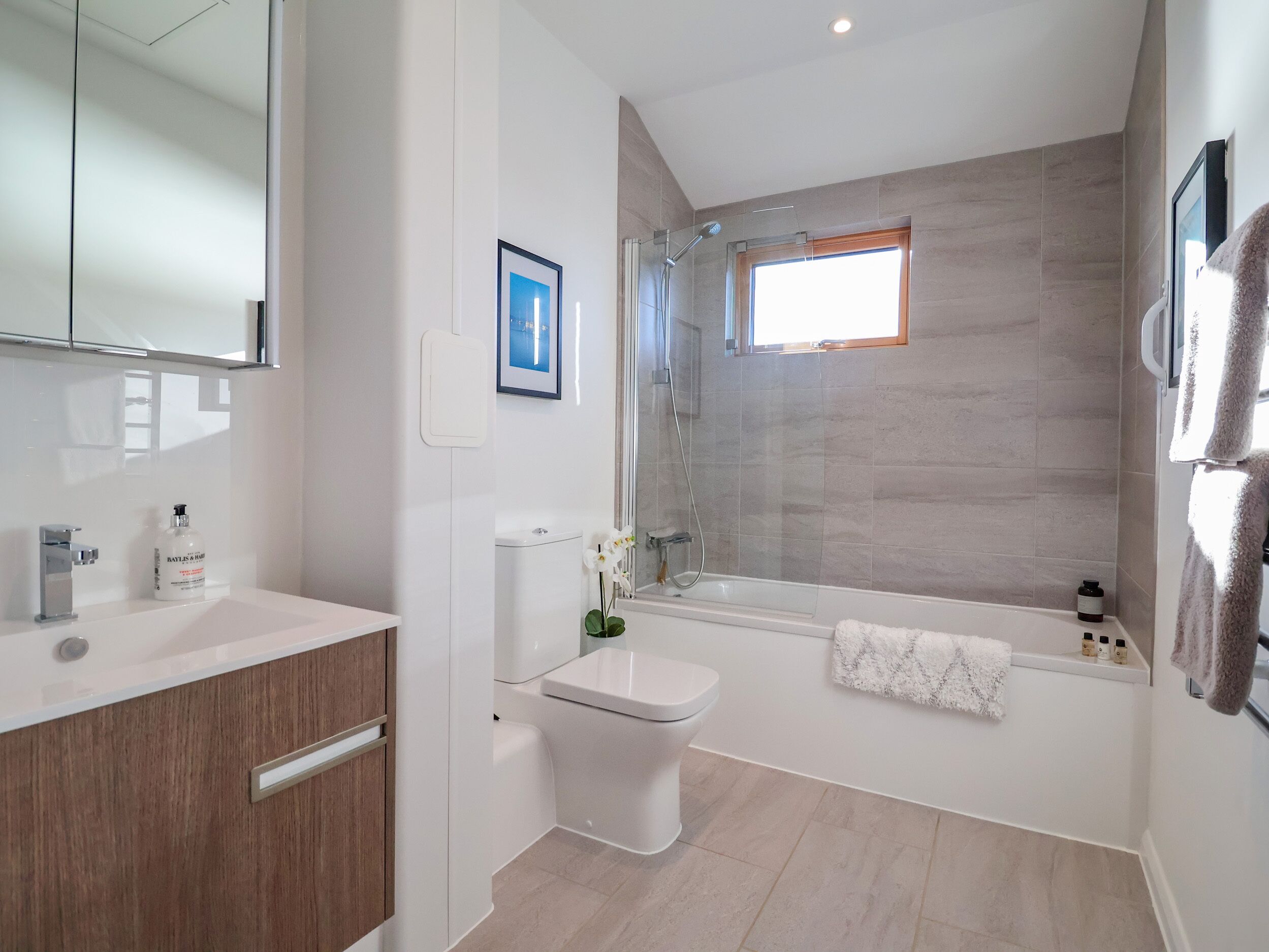 A modern bathroom with a shower, toilet, and sink.