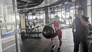 A gym with exercise equipment, a large window, and a person lifting weights. - Cozy 1BR cityview with Balcony and near Airport (Paranquae)