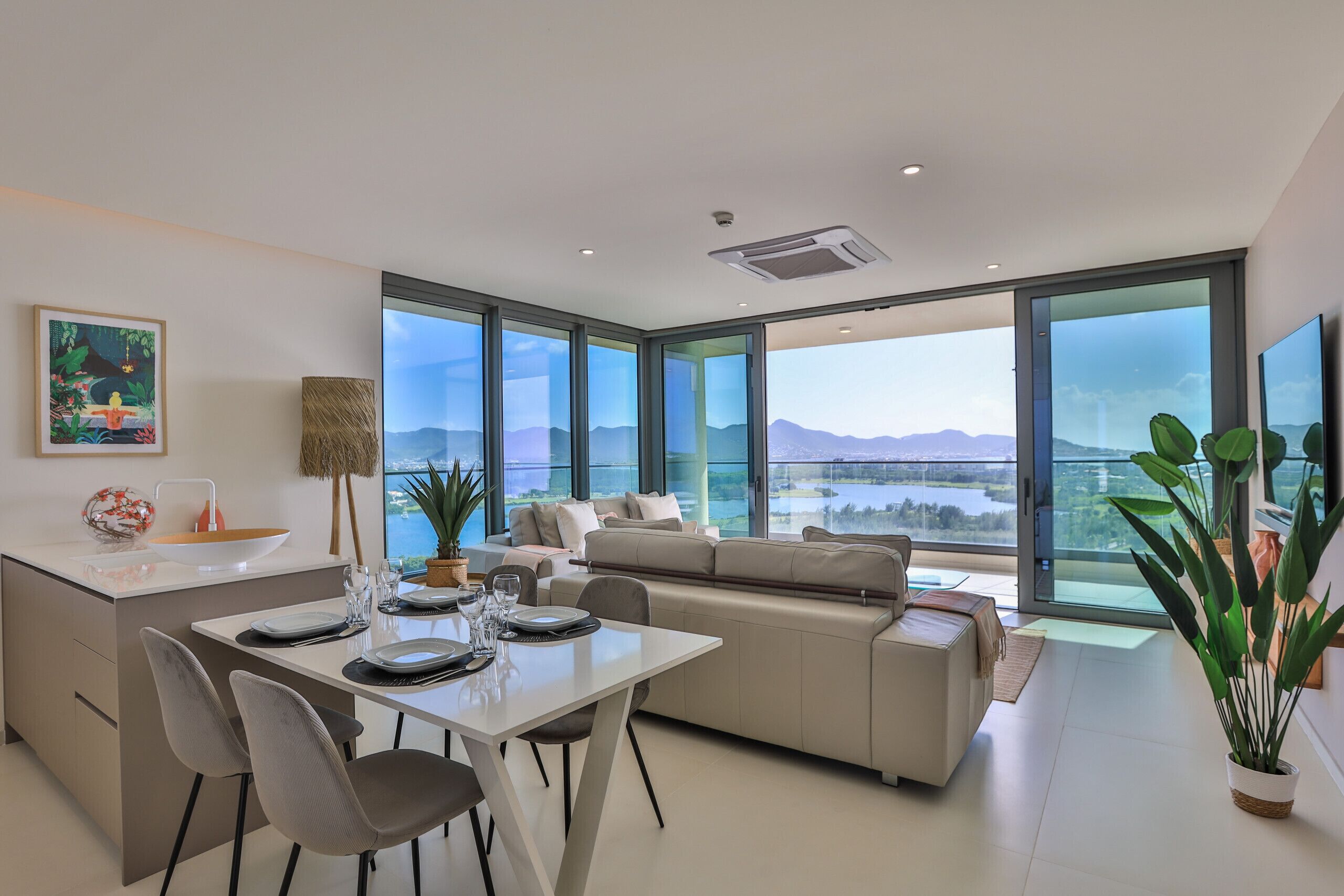 Ein modernes Wohnzimmer mit Essbereich, großen Fenstern und Bergblick.