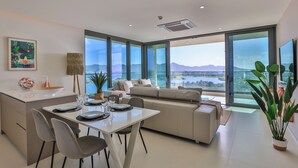 Una sala moderna con comedor, ventanas grandes y vistas a las montañas.