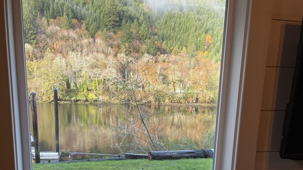 Un espace repas avec vue sur un lac et une forêt.