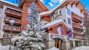 A lodge with a stone facade, wooden balconies, and a sign reading "Powderhorn Lodge".
