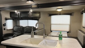 A compact kitchenette with a sink, faucet, and a bottle of hand sanitizer. - The Little Sweet Home (Spring Hill)