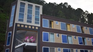 Een hotel met meerdere verdiepingen, met een modern ontwerp, een centrale trap en balkons.