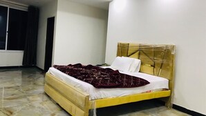 Een slaapkamer met een bed, hoofdeinde en raam.