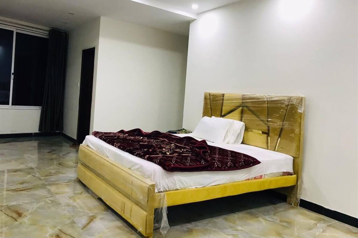 Ein Schlafzimmer mit Bett, Kopfstütze und Fenster.