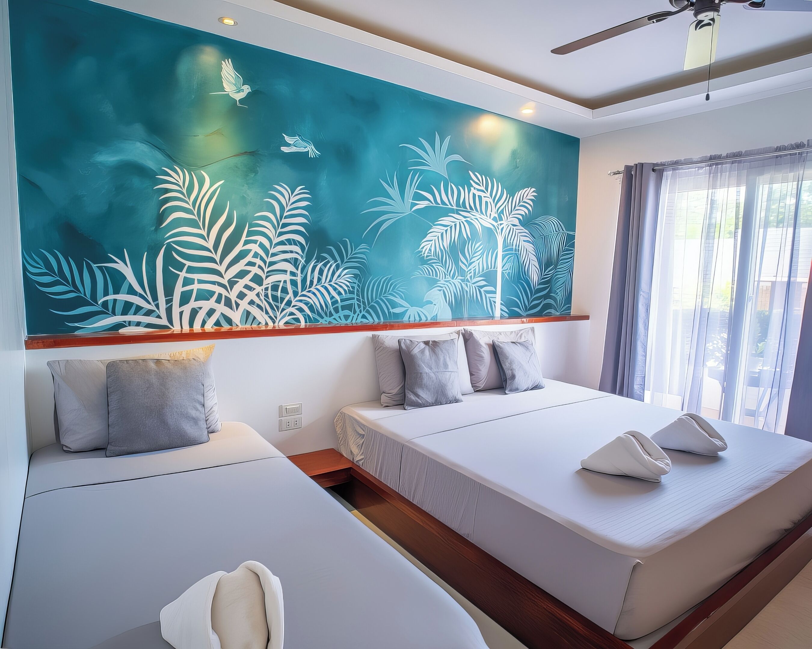 A modern hotel room with two beds, a large wall mural, and a view of the outdoors.