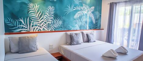 A modern hotel room with two beds, a large wall mural, and a view of the outdoors.