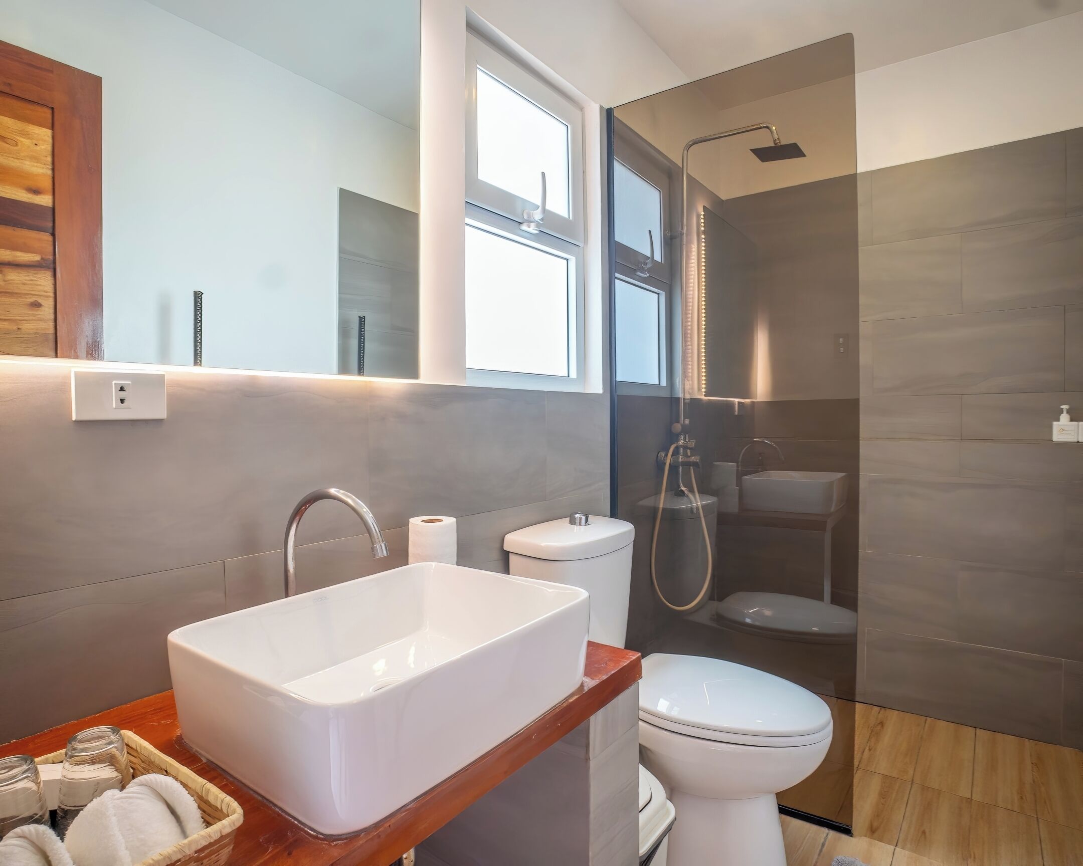 Une salle de bain moderne avec un grand lavabo blanc, des toilettes et un espace douche.