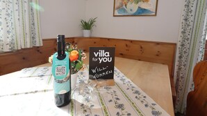 Une table avec une bouteille, un vase de fleurs et une pancarte indiquant « villa à votre disposition ».