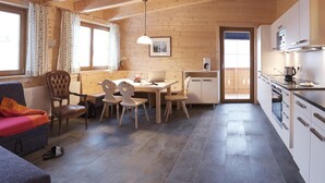 Un intérieur de chalet chaleureux comprenant un coin repas, une cuisine et un espace salon.