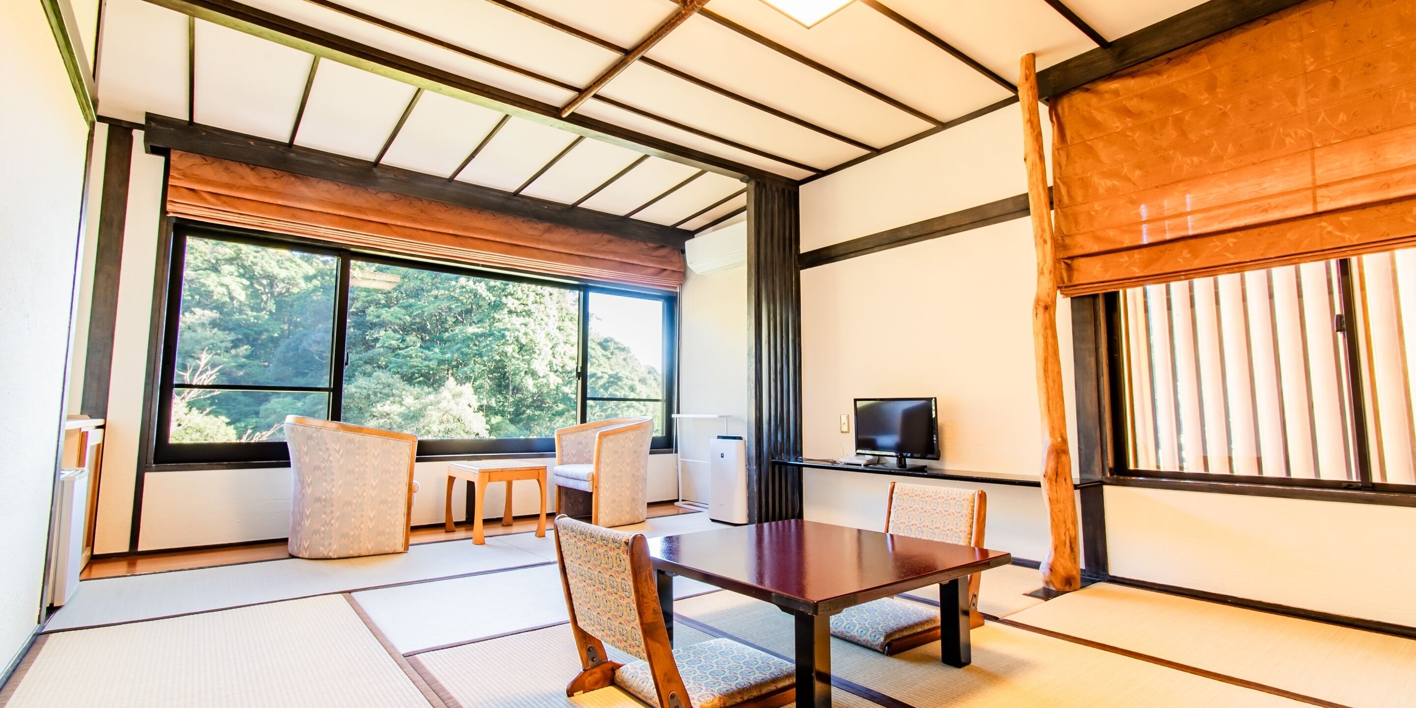 A traditional Japanese-style room with tatami flooring, a low table, and chairs.