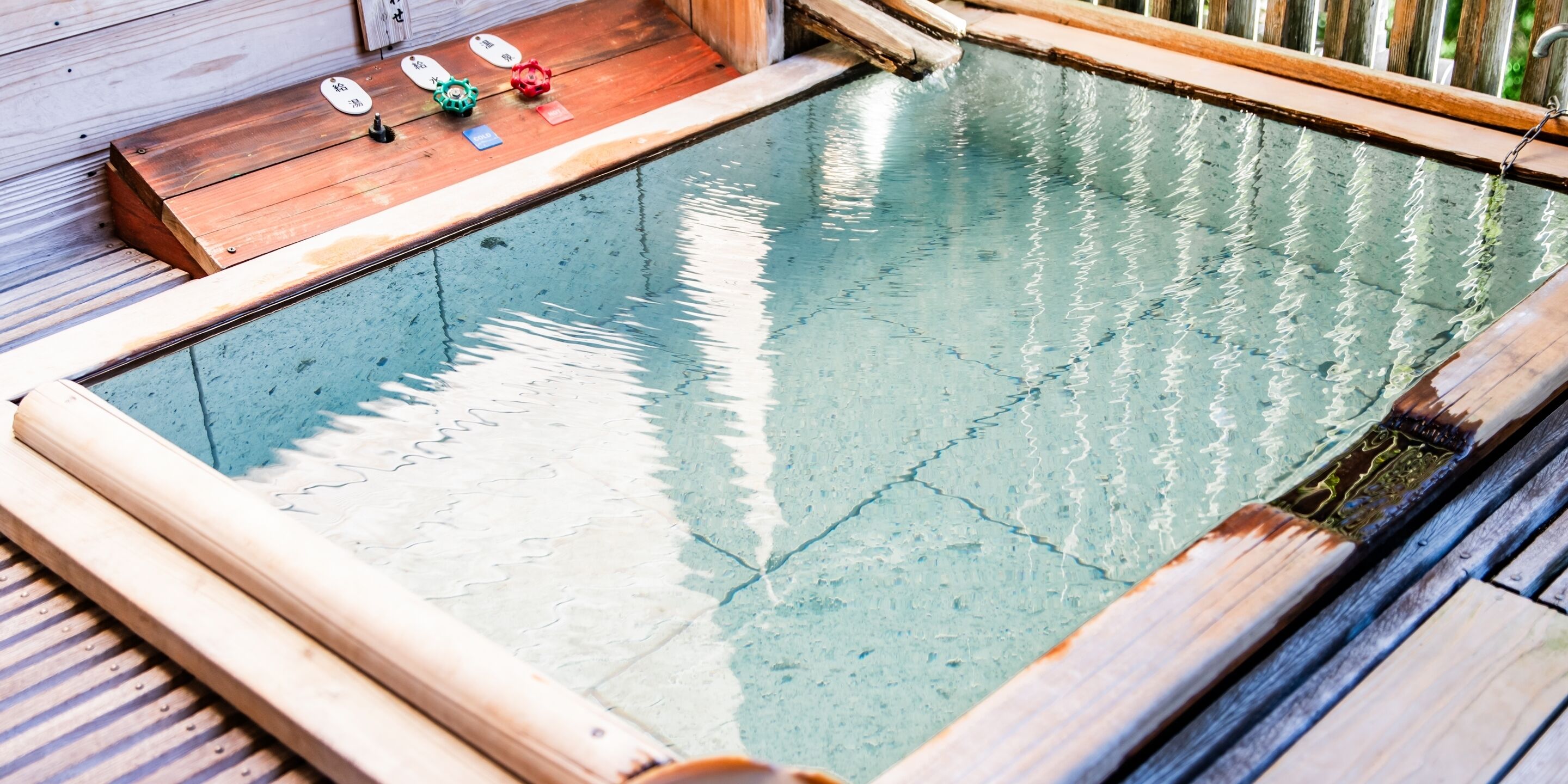 A wooden deck with a small pool, surrounded by wooden railings.