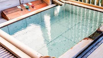 A wooden deck with a small pool, surrounded by wooden railings.