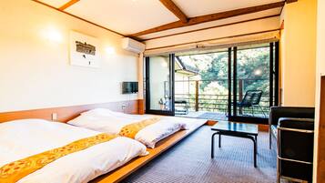 A hotel room with two beds, a small table, a chair, and a large window offering a view of the outdoors.