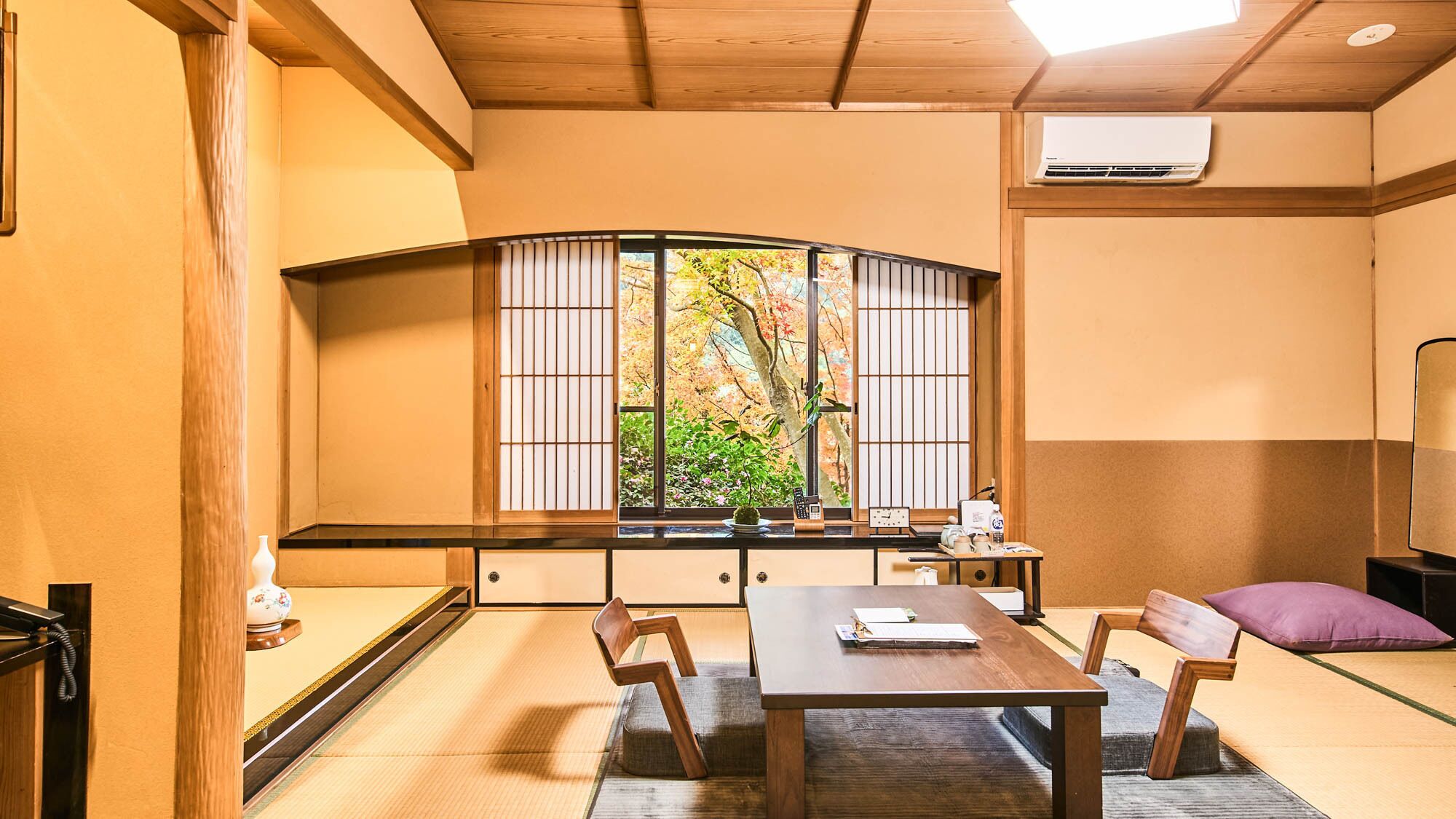 A traditional Japanese room with tatami flooring, a low table, and a shoji screen window.
