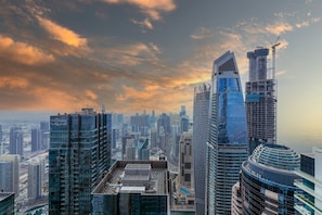 A high-rise building with a modern architectural design, featuring a curved glass facade and a rooftop terrace. - Maison Privee - High-Floor Trendy Apt w/ Marina, Palm & Ocean Vws (Dubai)