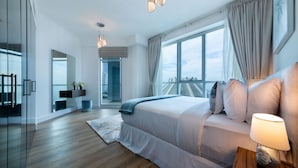 Ein modernes Schlafzimmer mit einem großen Bett, einem Nachttisch mit Lampe, Blick auf die Stadt durch große Fenster und einer Treppe, die zu einem Balkon im Freien führt.