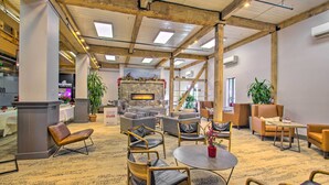 A spacious lobby with a stone fireplace, comfortable seating, and a carpeted floor. - Snug Wintergreen Resort Studio: Ski In & Out! (Wintergreen Resort)