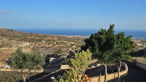 Eine Küstenlandschaft mit Blick auf das Meer, einer kurvenreichen Straße und verstreuten Gebäuden.