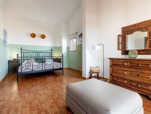 A bedroom with a bed, a dresser, a mirror, and a lamp.