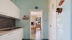 A kitchen with white cabinets, a sink, and a green-tiled floor. - 2349 Villa Mina by Barbarhouse (Melendugno)