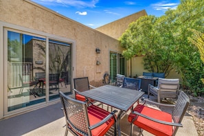 A patio with a table and chairs, a sliding glass door, and a potted plant. - Hidden Gem in Palm Desert, Steps to Living Desert! (Palm Desert)