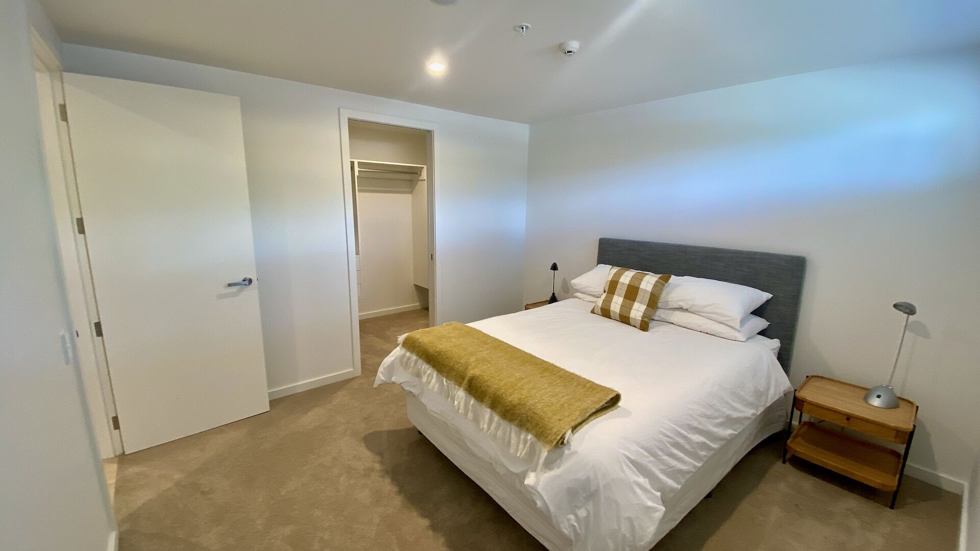 Quarto com cama, mesa de cabeceira e armário.
