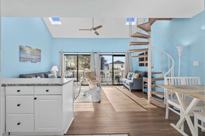 Enjoy a spacious living area with a central island counter, spiral staircase, and comfortable seating.
