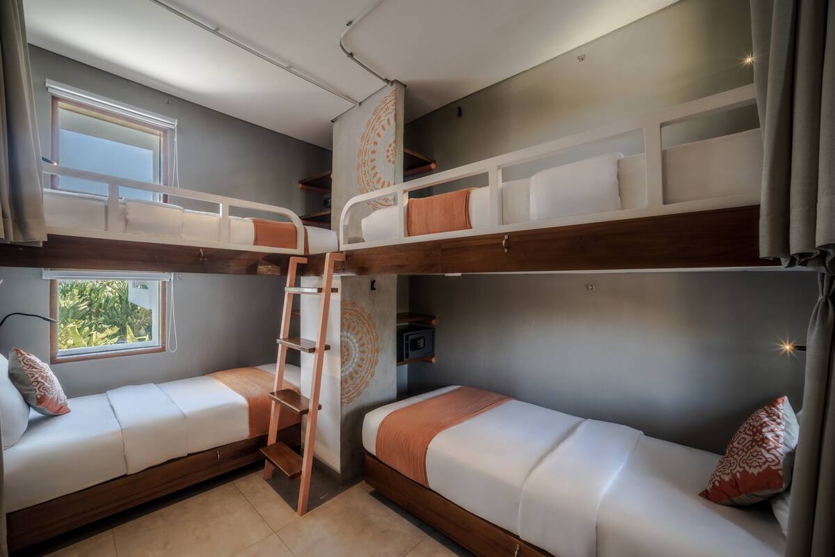 Habitación con literas, una escalera, una ventana y un adorno en la pared.