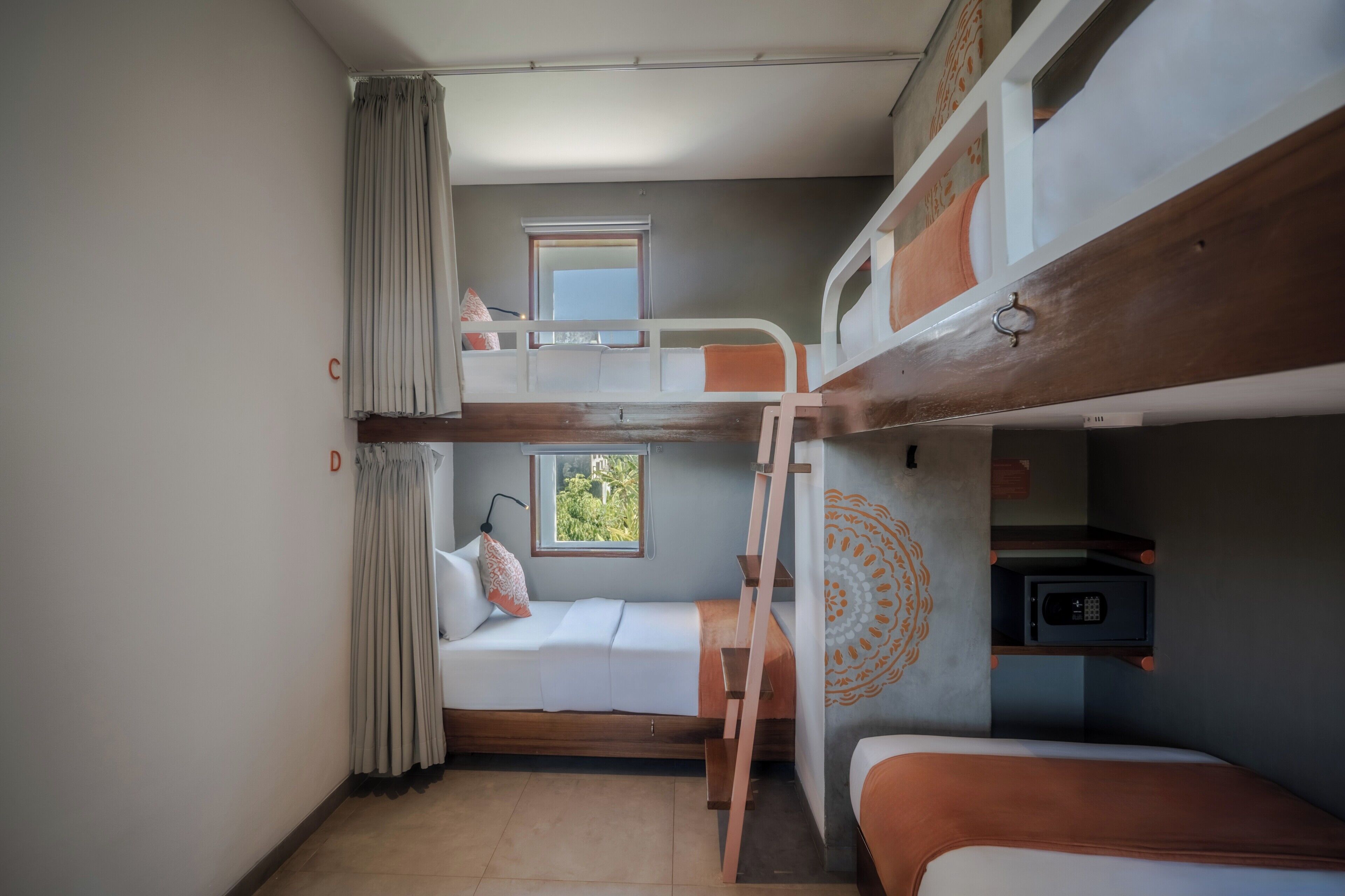 Habitación con literas, una ventana, una escalera y un microondas en un estante.