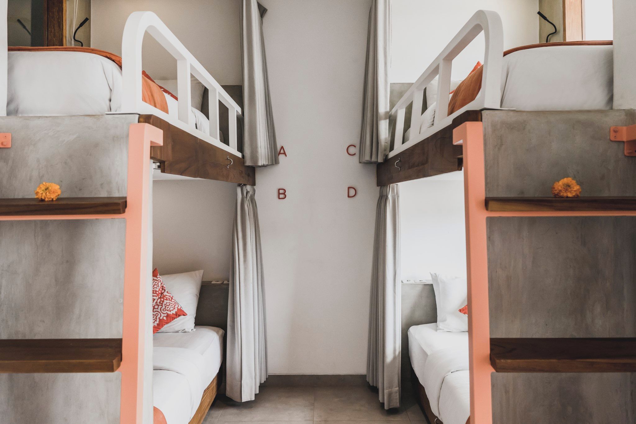 A room with bunk beds, a curtain, and a wall with letters A to D.