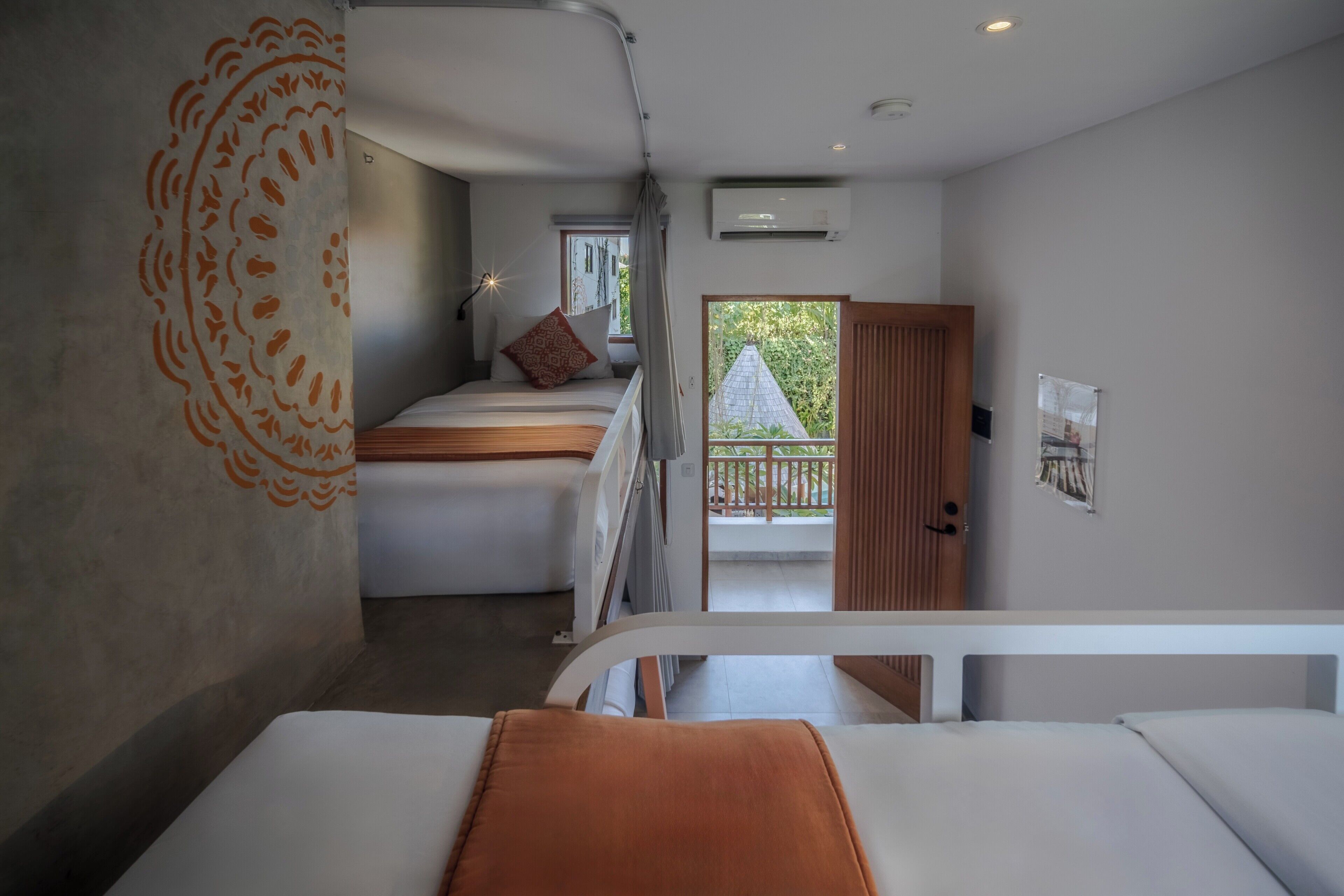 Een slaapkamer met een bed, een raam, een airconditioning en een balkon.