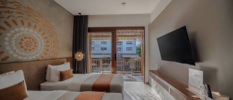 Habitación de hotel con dos camas, televisión, minibar y balcón con vistas a edificios.