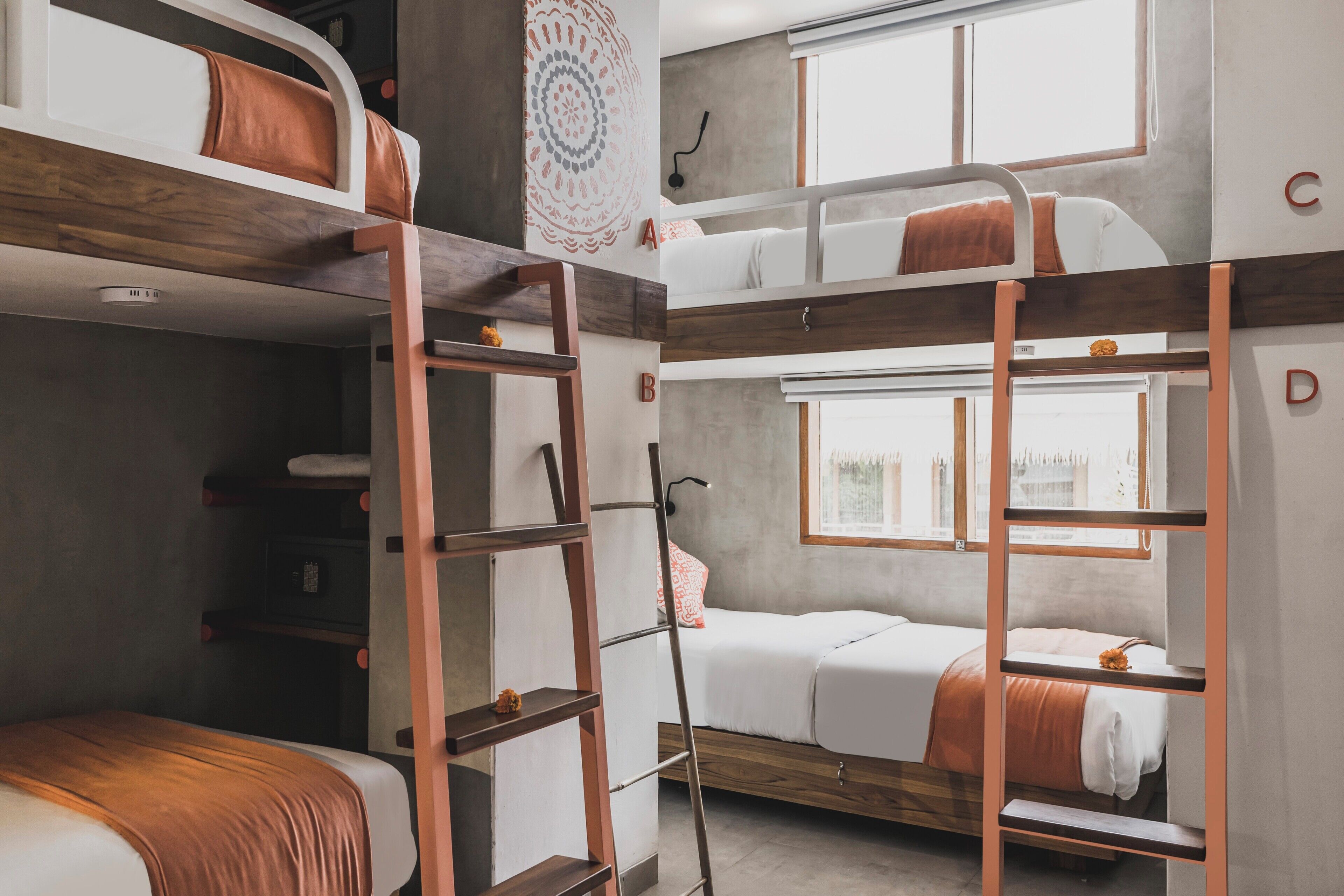 A bunk bed room with a ladder, a window, and a wall with letters.
