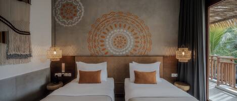 Habitación de hotel con dos camas, un mural grande en la pared, un balcón con vistas y un tapiz tejido.