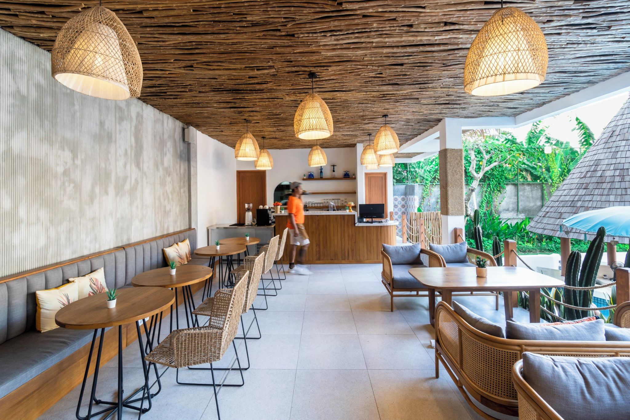 A restaurant with a rustic ceiling, multiple hanging lights, and a bar area.