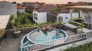 A rooftop swimming pool with a view of the cityscape.