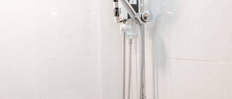 A modern shower with a handheld showerhead and a wall-mounted control panel.