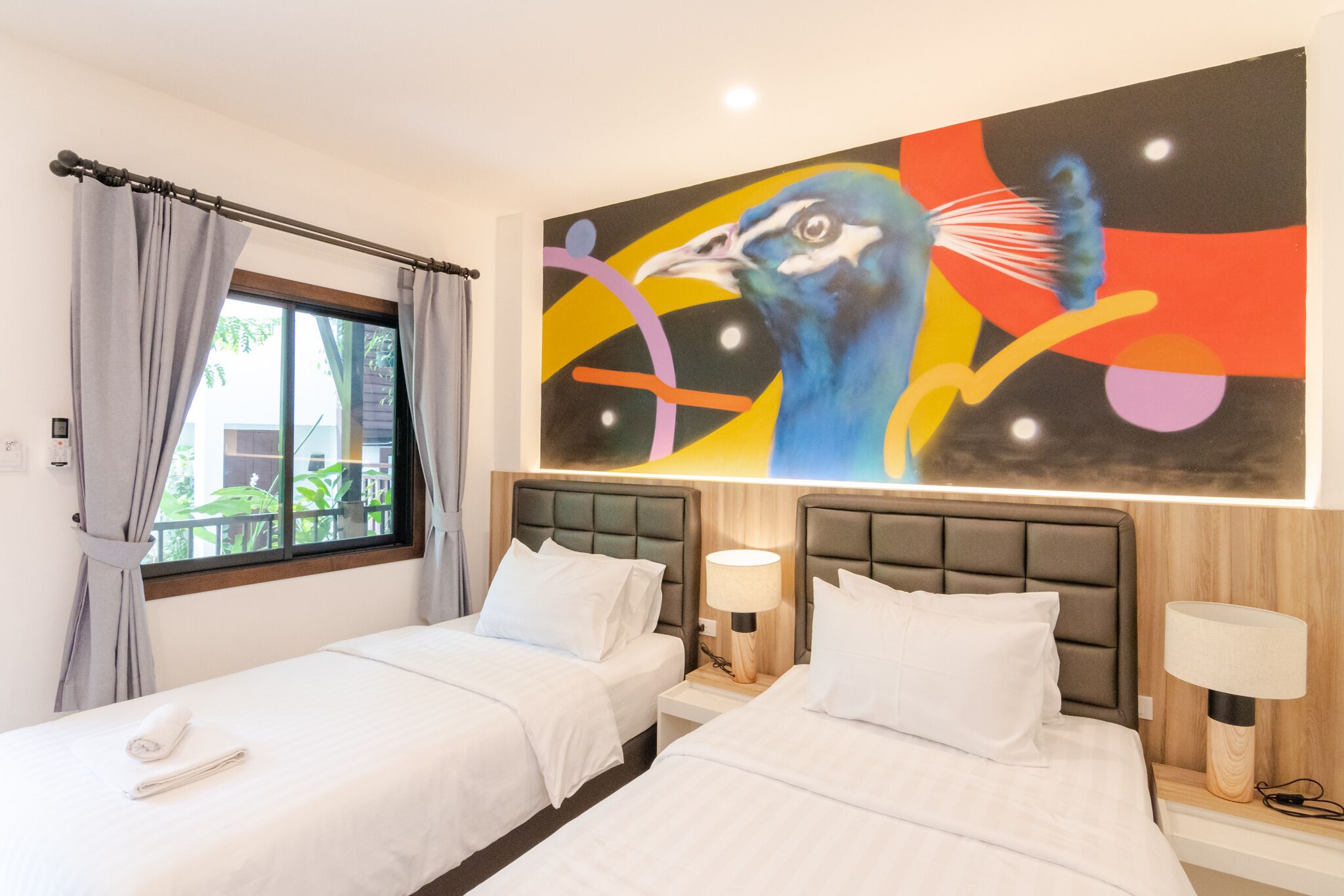 A hotel room with two beds, a large abstract painting on the wall, and a window with curtains.