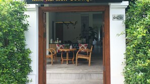 L’entrée du Nine-Kai-Mon Boutique Hotel présente un style architectural thaïlandais traditionnel, avec une porte en bois et un toit recouvert de tuiles.