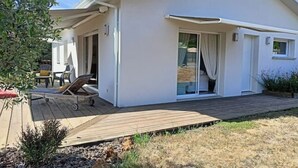 A modern house with a covered patio, a sliding glass door, and a small deck. - 3 bedroom house on the edge of a forest (Salles)
