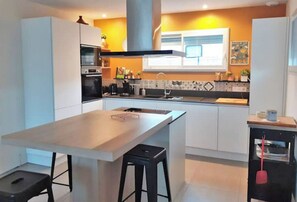 Enjoy cooking in this well-equipped kitchen with a central island and bar stools.