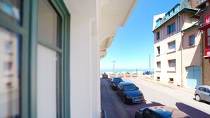 A street view with parked cars and a building with balconies overlooking a clear sky. - Villa Adèle, Escapade Belle-Époque - Appt 01 (Mers-les-Bains)
