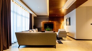 A modern living room with a sofa, a coffee table, and a TV. - Blackwood Hotel and Apartments (Dar es Salaam)