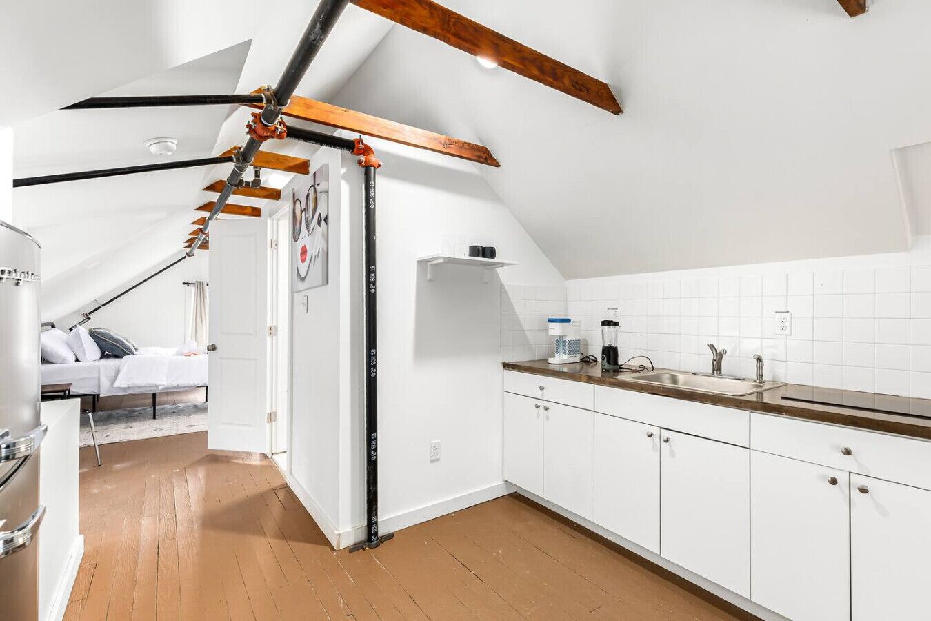 Eine moderne Küche mit weißen Schränken, einer Holzarbeitsplatte und einem Deckenventilator.